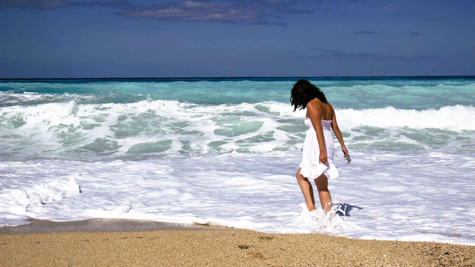 Mujer caminando por una playa al amanecer simbolizando transformación personal