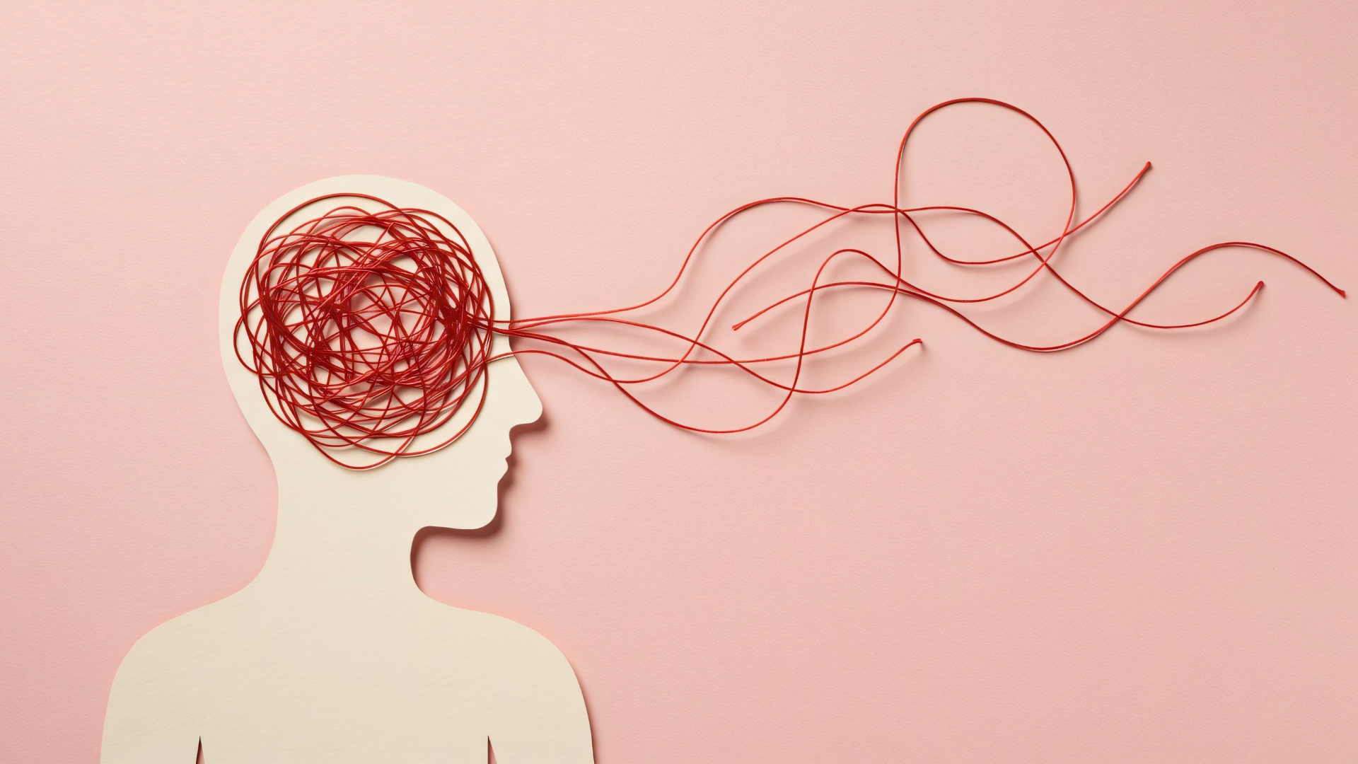 Silueta de una cabeza con hilos rojos enredados, metáfora de la ansiedad y la dicotomía del control